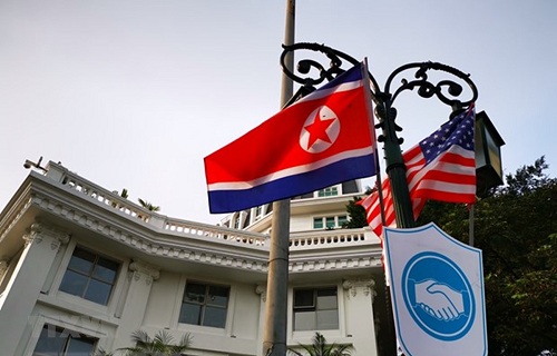 Cờ Mỹ và cờ Triều Tiên, bên dưới là biểu tượng hai bàn tay bắt chặt vào nhau thể hiện tinh thần của cuộc gặp lớn, được treo bên ngoài khu vực Quảng trường 19/8 - Nhà hát Lớn - Khách sạn Hilton Opera, Quận Hoàn Kiếm.